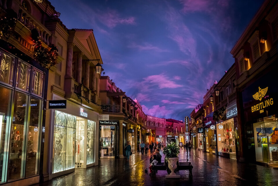 Beleuchtete Luxus-Einkaufsstraße spät in der Nacht.